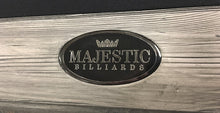 Load image into Gallery viewer, The Majestic Billiards brand crest proudly inserted into the beautiful rustic aged-looking barnwood finished rail of the Pioneer model pool table